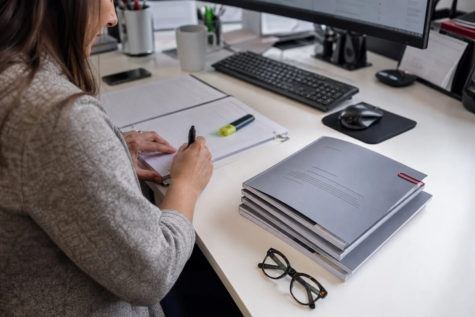 A stack of printed regulatory guidance documents with a new one on top marked by a paper clip